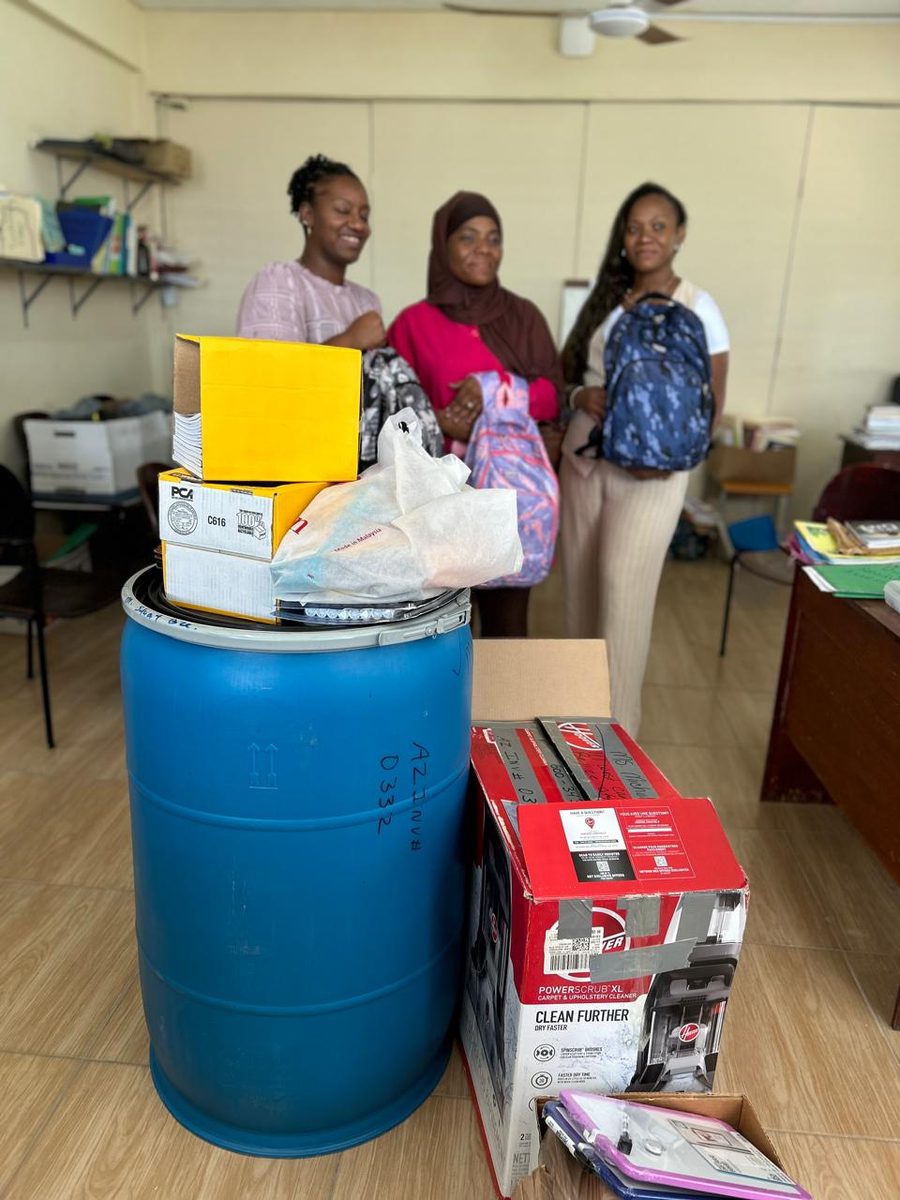 School staff member speaking with students as they receive supplies